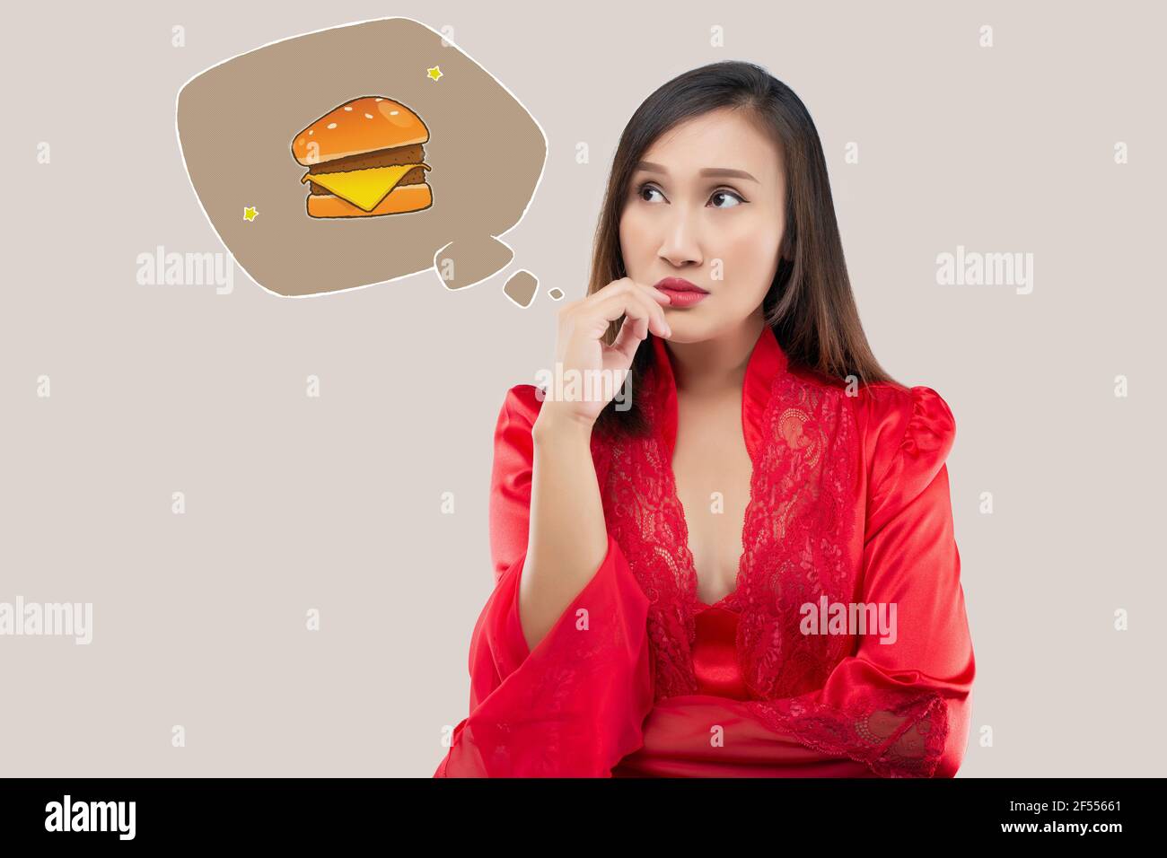 A woman want to eat hamburgers during the night. When a woman in a red satin nightgown and lace robe wake up hungry late at night. Food cravings Stock Photo