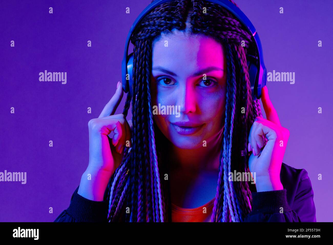 Beautiful woman with long hair in braids listening to music with ...