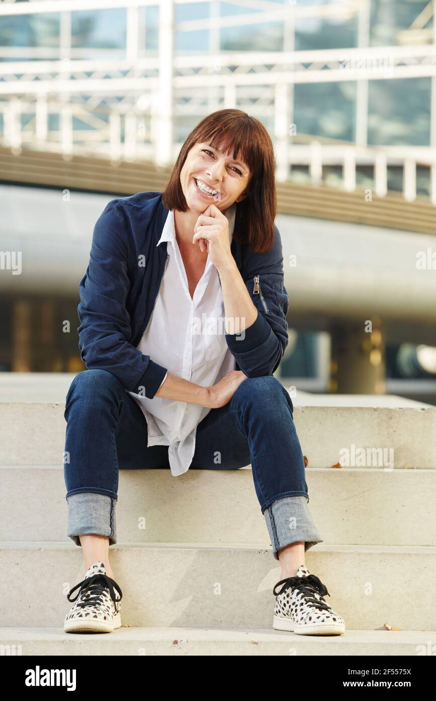 Portrait of smiling older woman sitting on steps outside Stock Photo ...