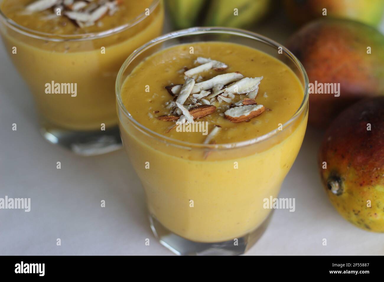 Mango Banana Smoothie, A deliciously thick and creamy banana smoothie bursting with mango flavour. Made with only 5 simple ingredients. Shot on white Stock Photo