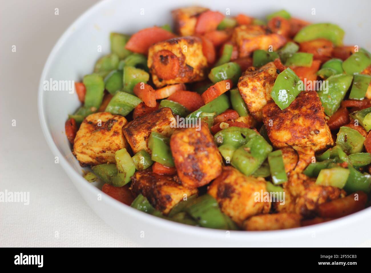 Tawa roasted paneer with sauteed carrots and capsicum. A quick lunch or dinner option. Shot on white background Stock Photo