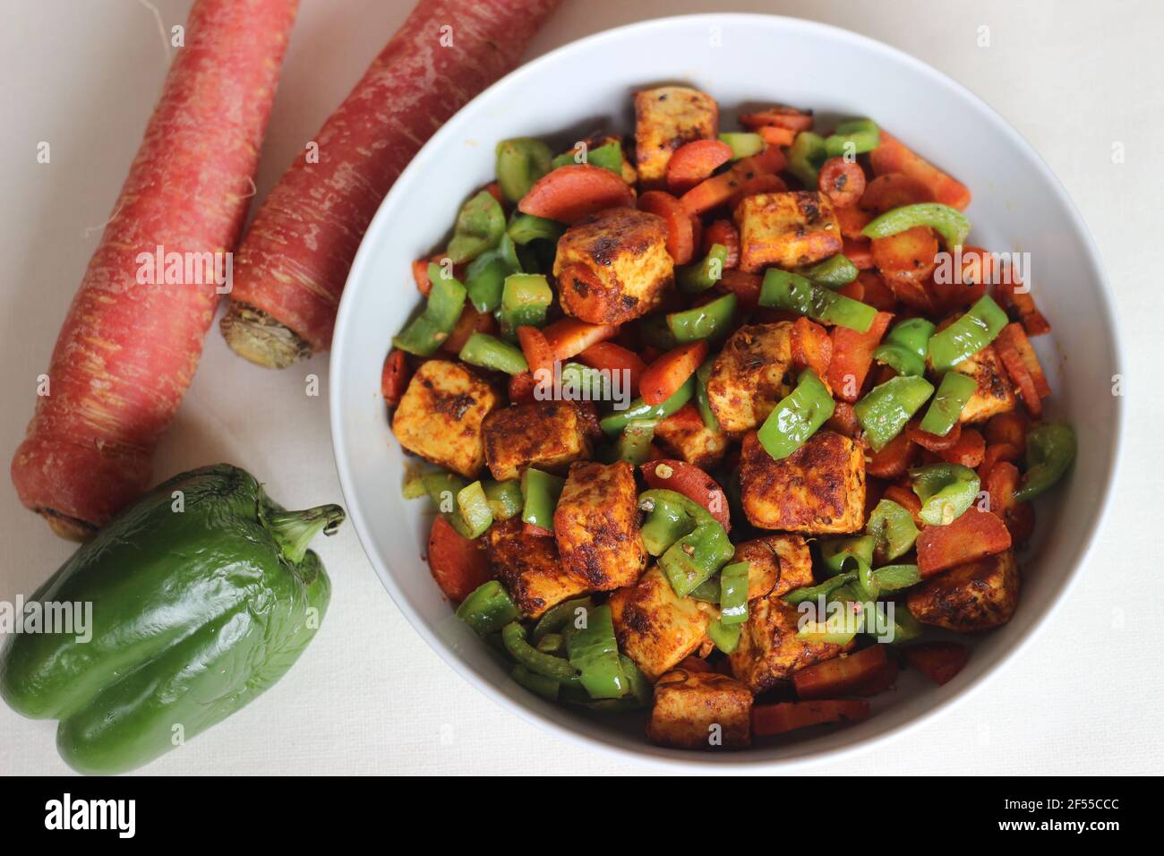 Tawa roasted paneer with sauteed carrots and capsicum. A quick lunch or dinner option. Shot on white background Stock Photo