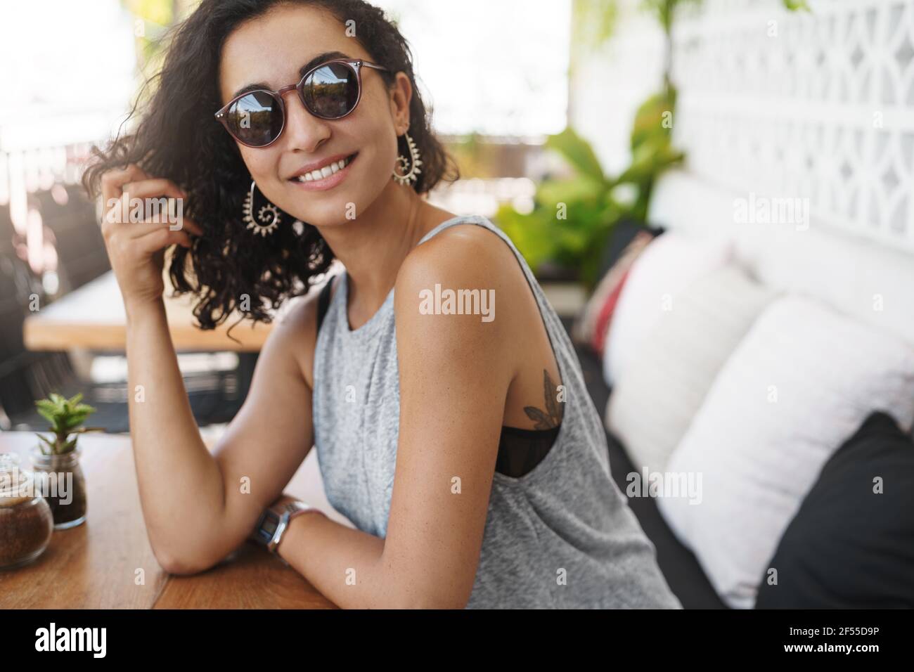 You are smooth talker. Attractive flirty girl sitting cafe patio summer sunglasses lean coffee table turn camera joyfully smiling woman enjoying Stock Photo
