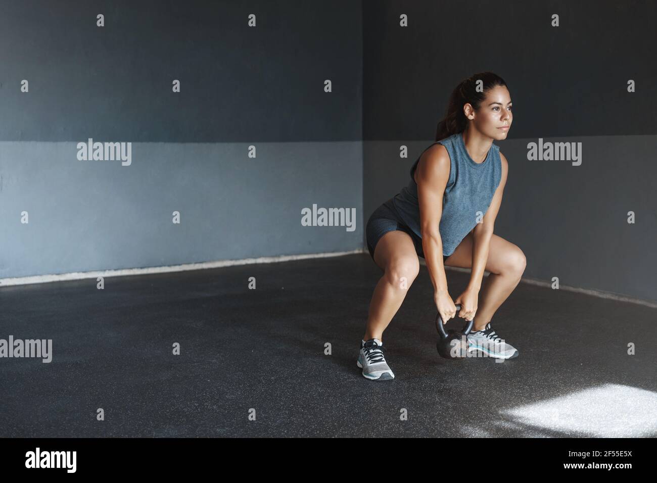 One more sit-up to achieve goal. motivated hispanic sportswoman wear activewear, look determined hold kettlebell, make fitness crossfit Stock Photo - Alamy