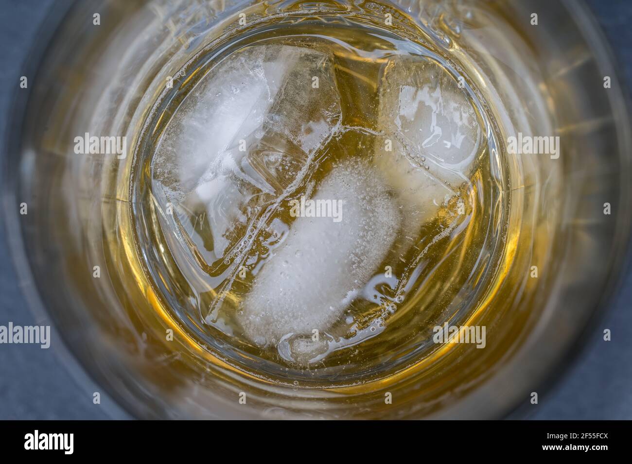 Glass with whiskey on the rocks as background in detail Stock Photo