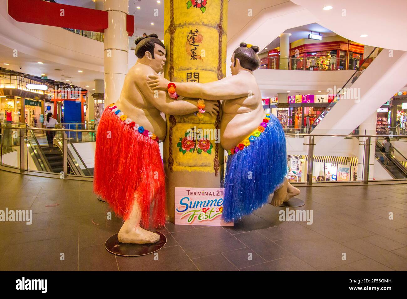 Fun, silly interior of Terminal 21 shopping mall with unique models. Here, two Japanese sumo wrestlers with Hawaiian grass skirts. In Bangkok, Thailan Stock Photo