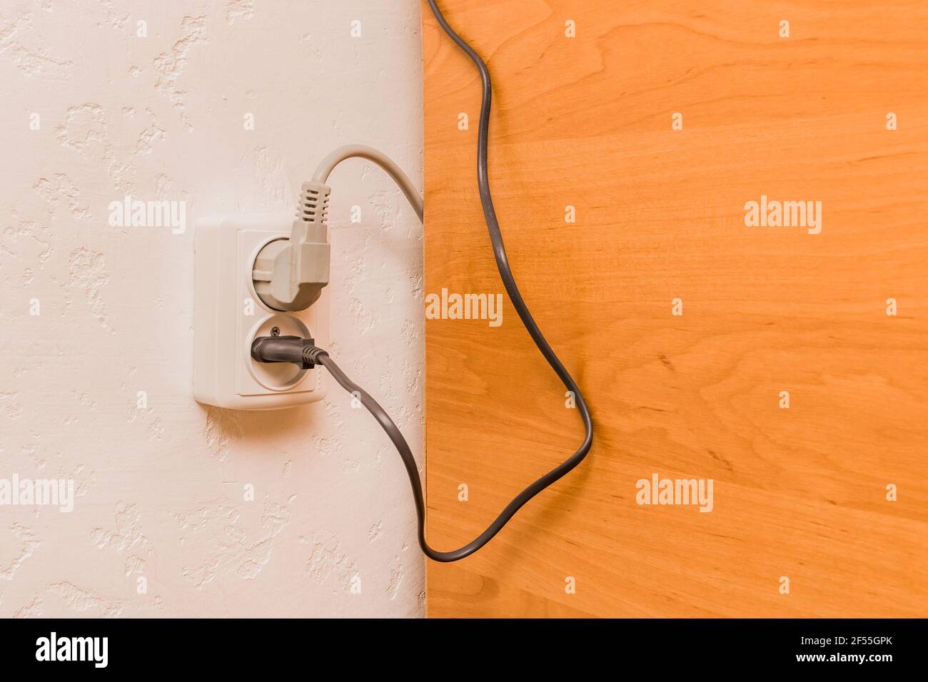 Two plugs in the socket in a modern interior. Safe connection of