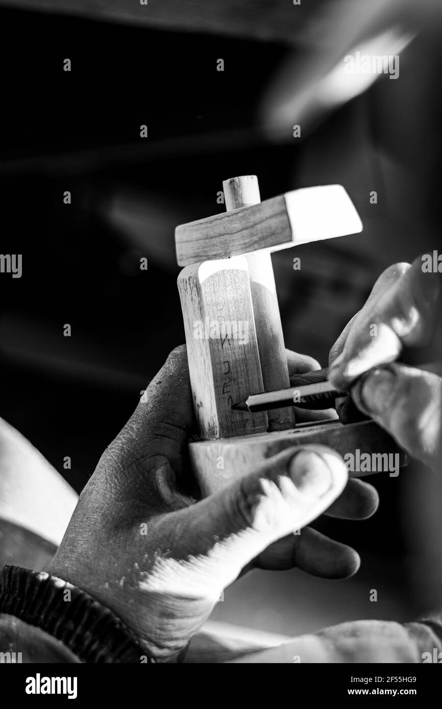 Carpenter carving figurine in old workshop Stock Photo