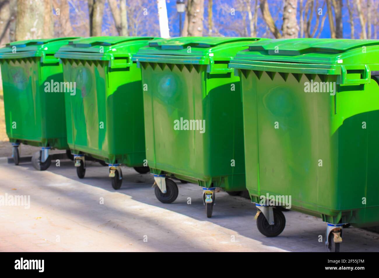 https://c8.alamy.com/comp/2F55J7M/large-green-plastic-trash-cans-on-city-street-containers-on-wheels-with-a-handle-to-collect-commercial-and-resident-trash-disposal-of-household-and-2F55J7M.jpg