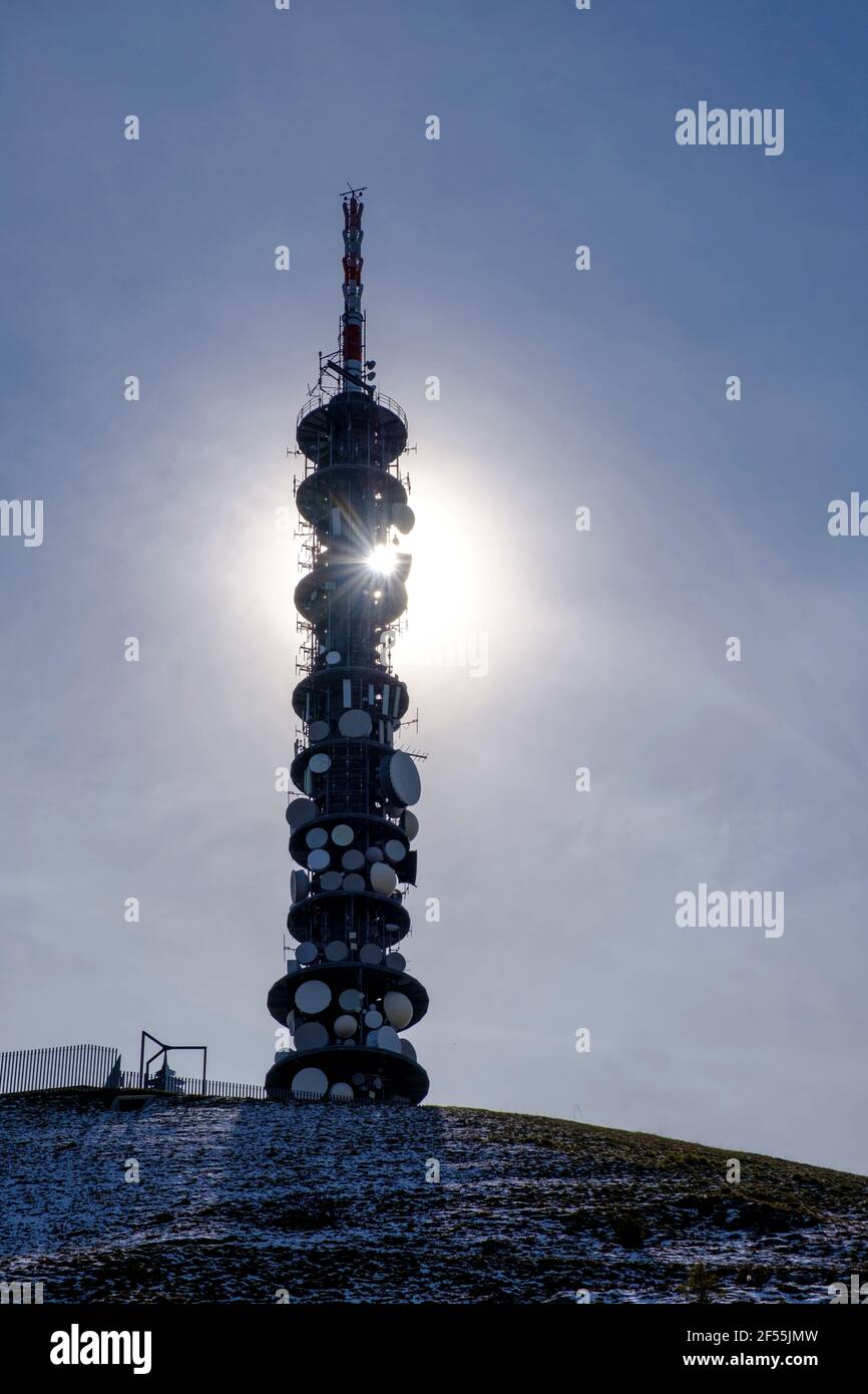 Italy, Kronplatz mountain communications tower standing against shining sun Stock Photo
