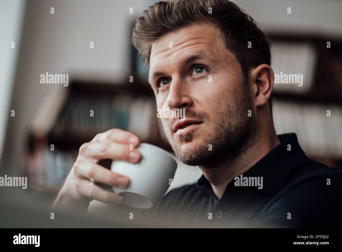 Thoughtful businessman looking away while having coffee at cafe Stock Photo