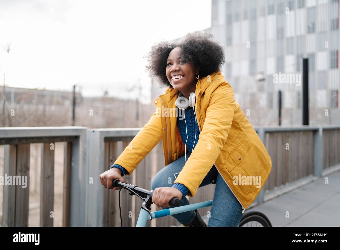Smiling woman cycling on footpath Stock Photo