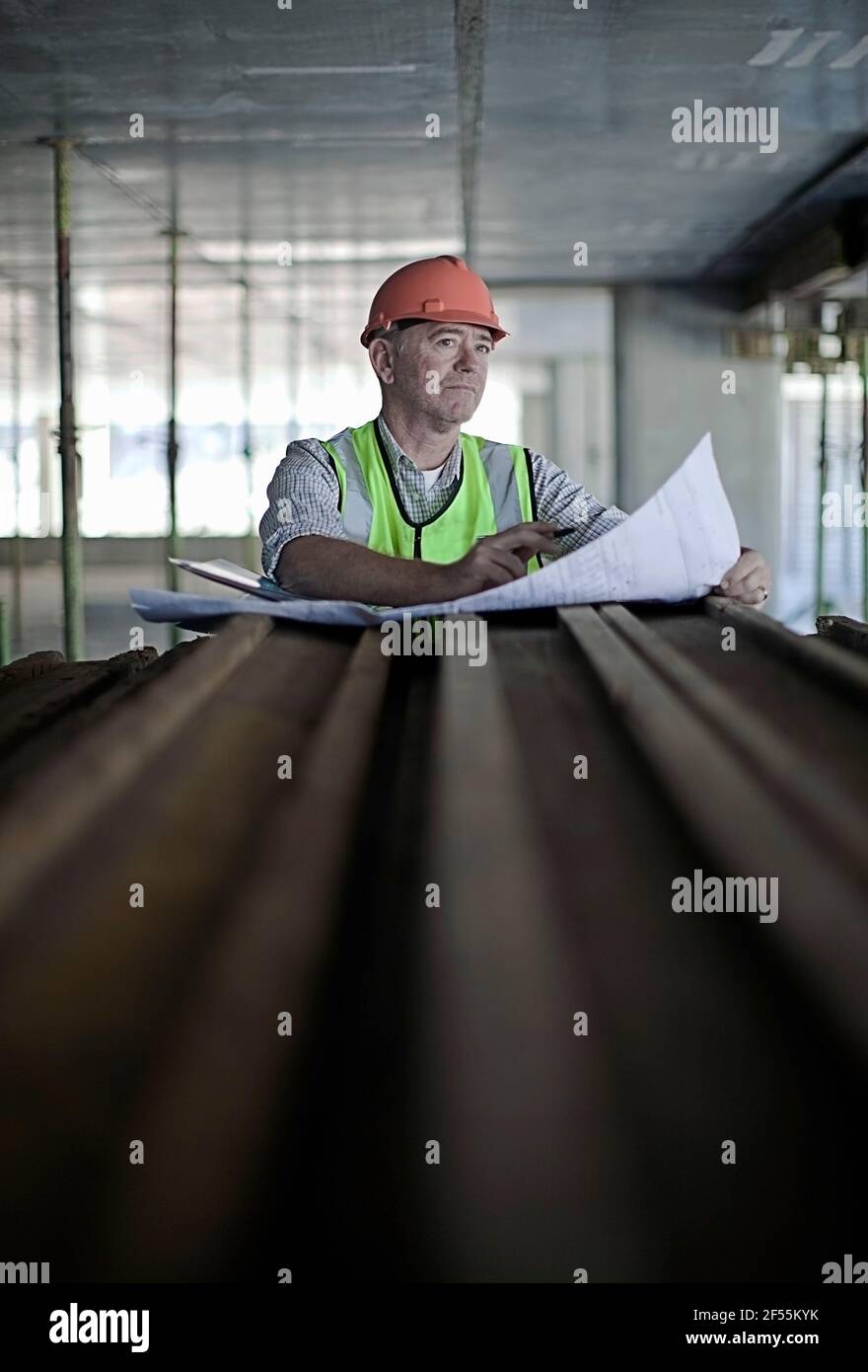 Male construction worker with blueprint planning at construction industry Stock Photo