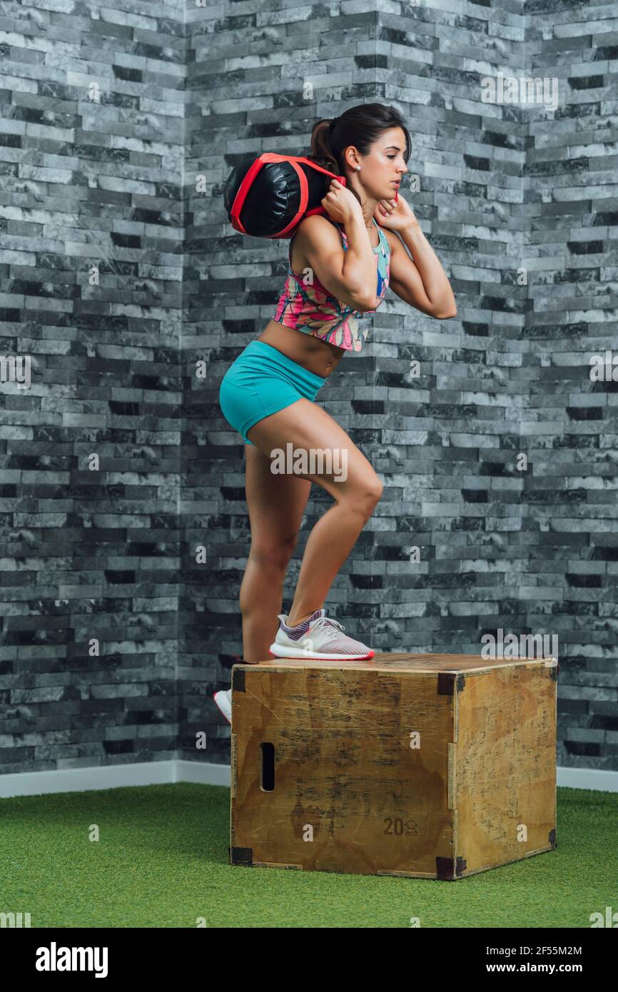 Female athlete practicing with punching bag in gym Stock Photo