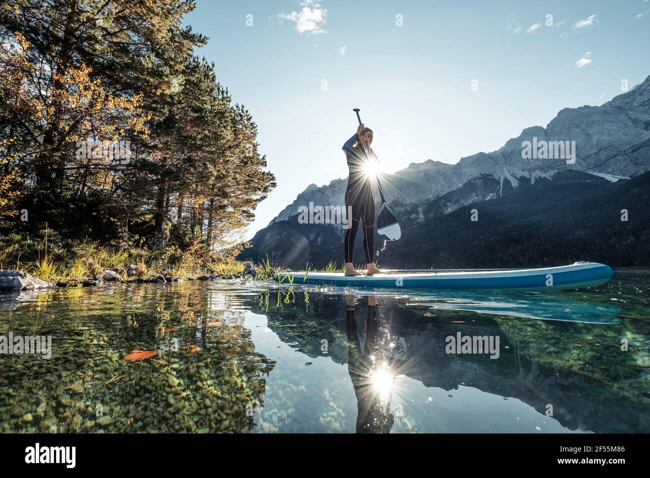 Germany, Bavaria, Garmisch Partenkirchen, Young woman stand up paddling