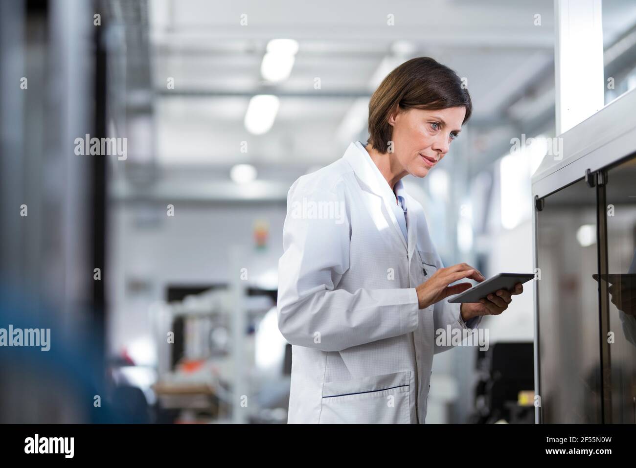Mature female technician using digital tablet at laboratory Stock Photo
