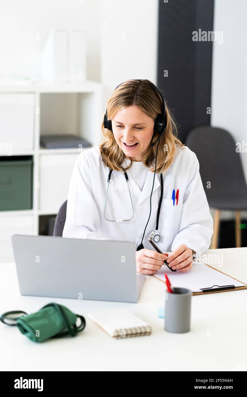 Female doctor giving online consultation through laptop in medical clinic Stock Photo