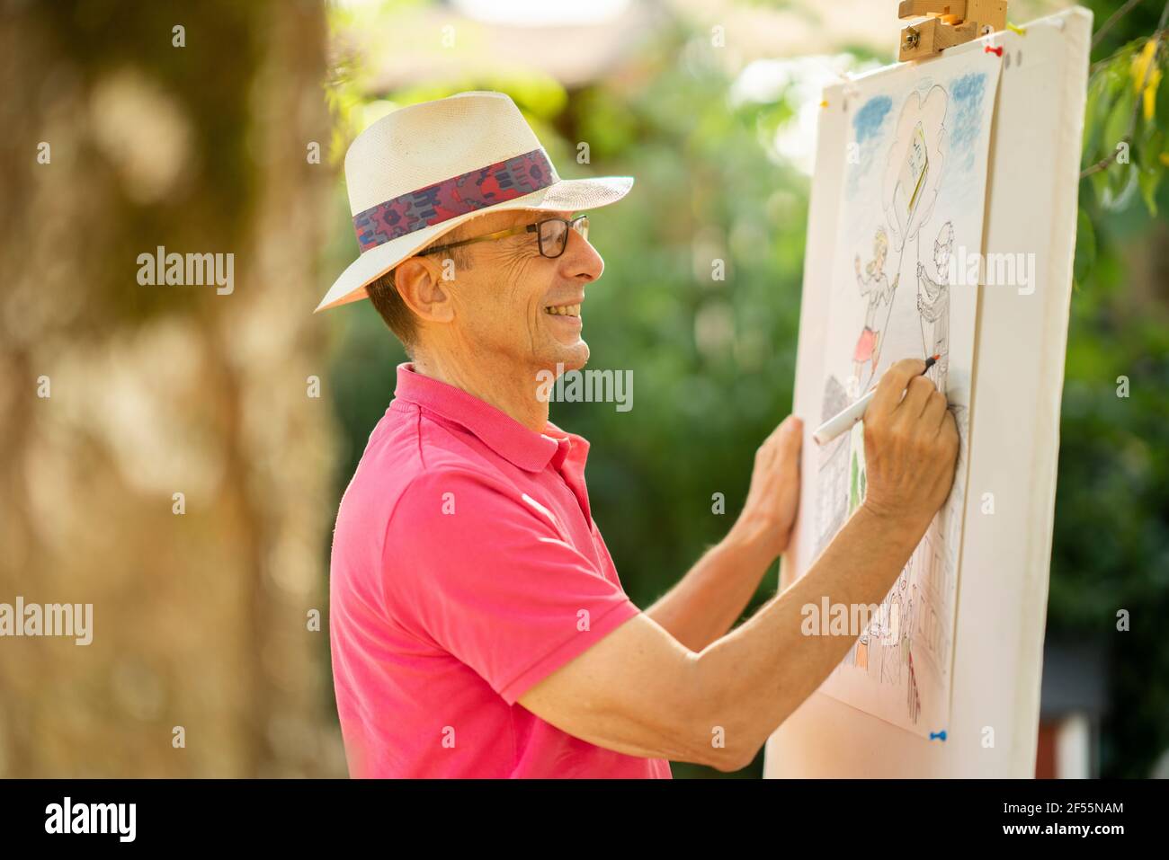 Smiling elderly man drawing in back yard garden Stock Photo