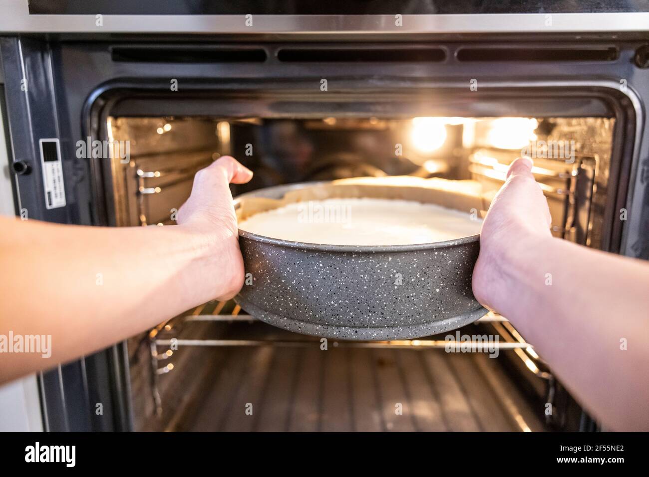 Woman putting a cheesecake in the oven Stock Photo Alamy