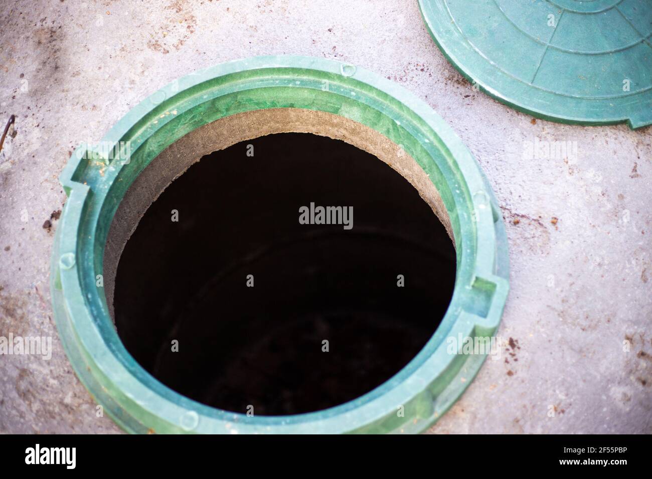 Construction of a septic tank. Large concrete rings with an open sewer hatch, unprotected by a cover from falls and accidents.. Stock Photo