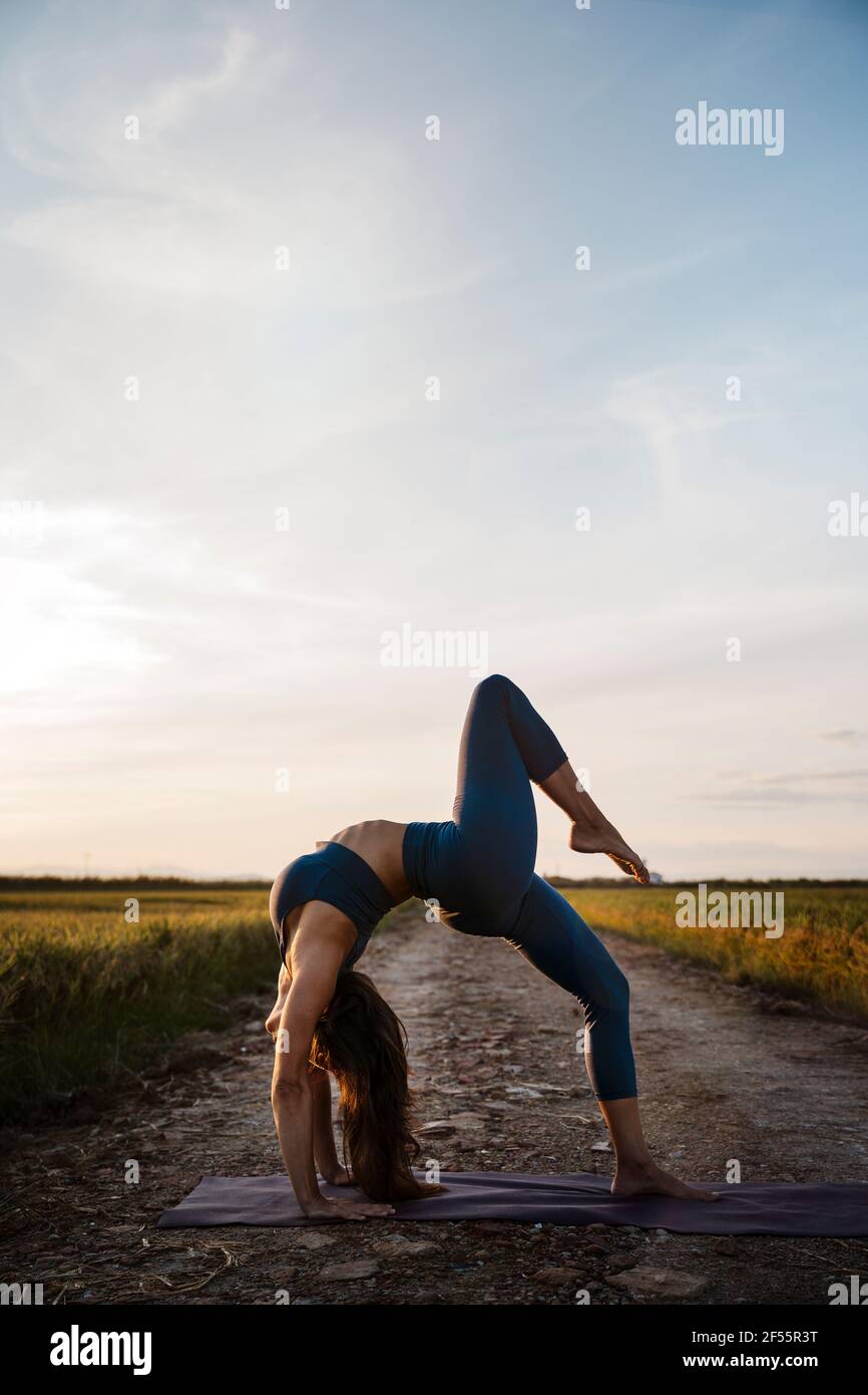 Woman bending over backwards while practicing yoga Stock Photo