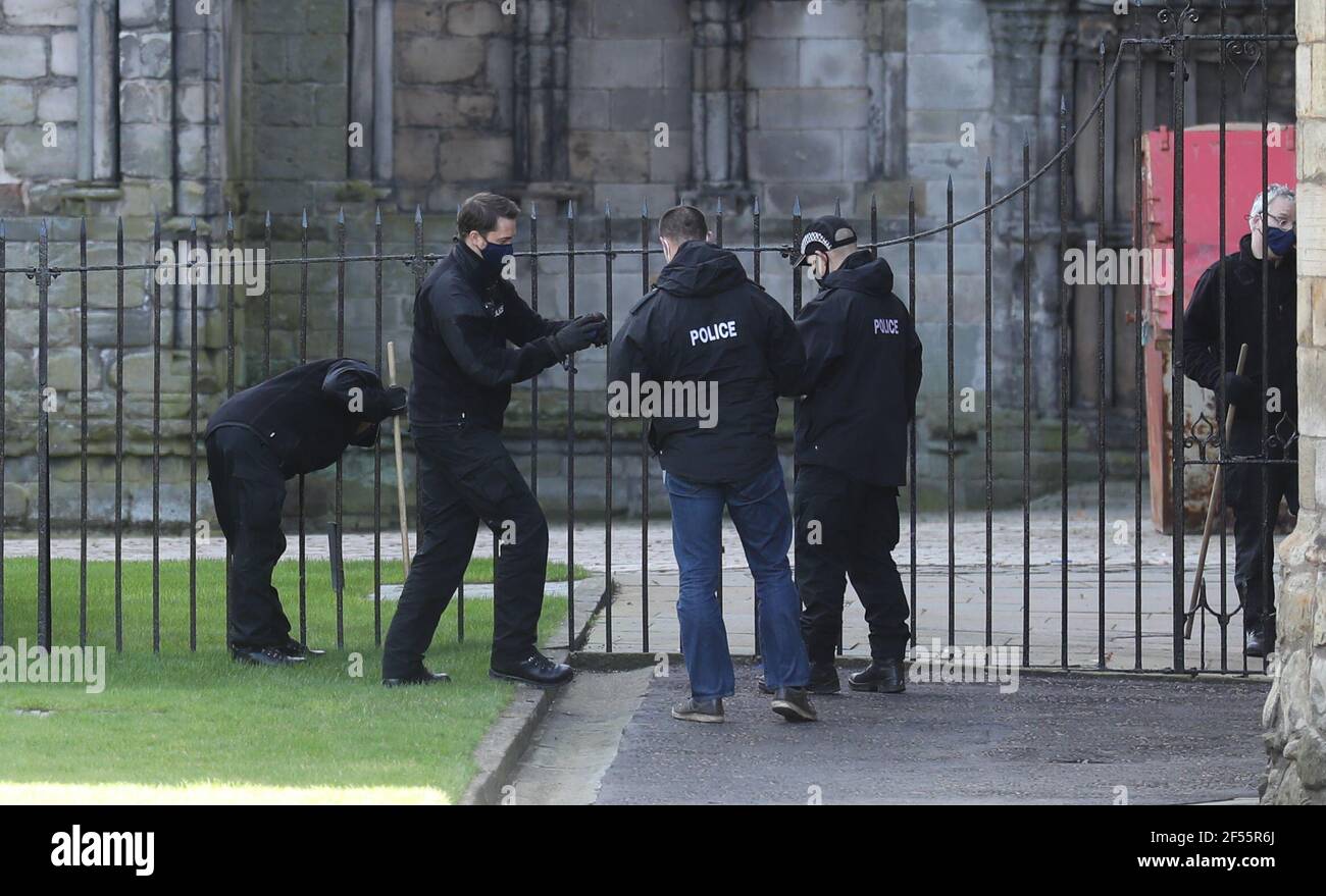 Police officers put something in a bag as they conduct a search within