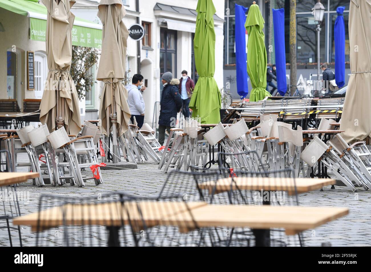 Munich, Deutschland. 23rd Mar, 2021. Topic picture: Coronavirus pandemic/consequences for gastronomy: stacked and folded chairs in front of a restaurant, outdoor gastronomy on March 23, 2021. | usage worldwide Credit: dpa/Alamy Live News Stock Photo