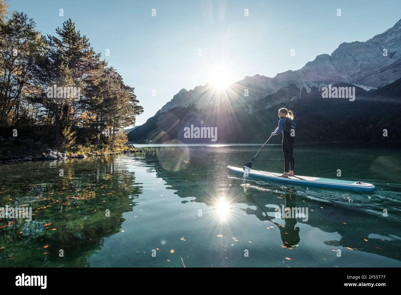 Germany, Bavaria, Garmisch Partenkirchen, Young woman stand up paddling