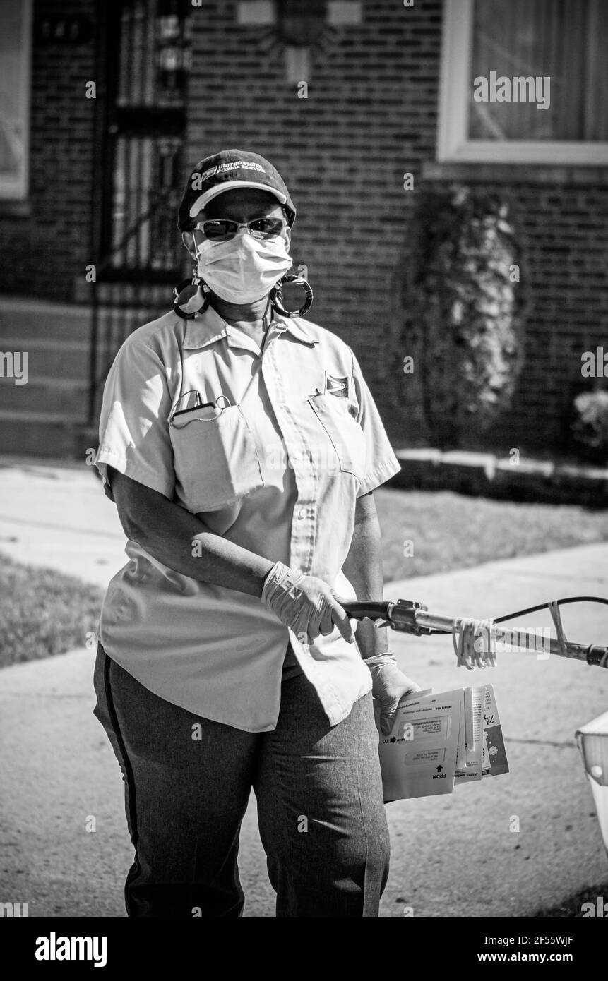 CHICAGO, IL. USA APRIL 8, 2020: USA POSTAL WOMAN DELIVERS MAIL ON THE FAR SOUTH SIDE OF THE CITY, THE WEST PULLMAN AREA DURING THE HEIGHT OF COVID 19 Stock Photo