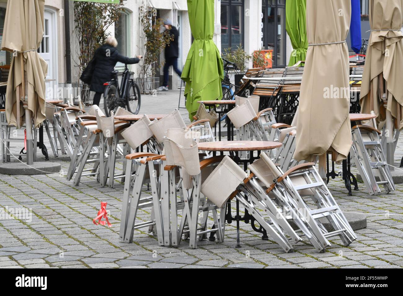 Munich, Deutschland. 23rd Mar, 2021. Topic picture: Coronavirus pandemic/consequences for gastronomy: stacked and folded chairs and tables in front of a restaurant, outdoor catering on 23.03.2021. | usage worldwide Credit: dpa/Alamy Live News Stock Photo