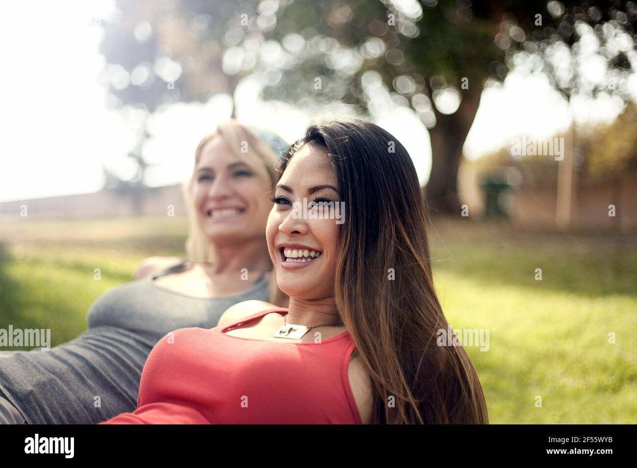 Cheerful young woman with female friend at park Stock Photo