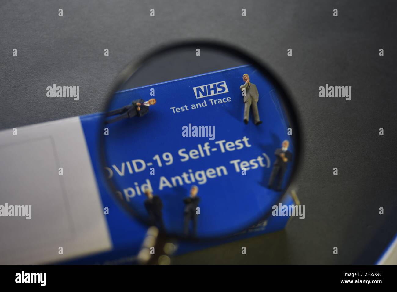 A COVID-19 Self Test (Rapid Antigen Test) kit information concept image. Selective focus through a magnifying glass. Stock Photo