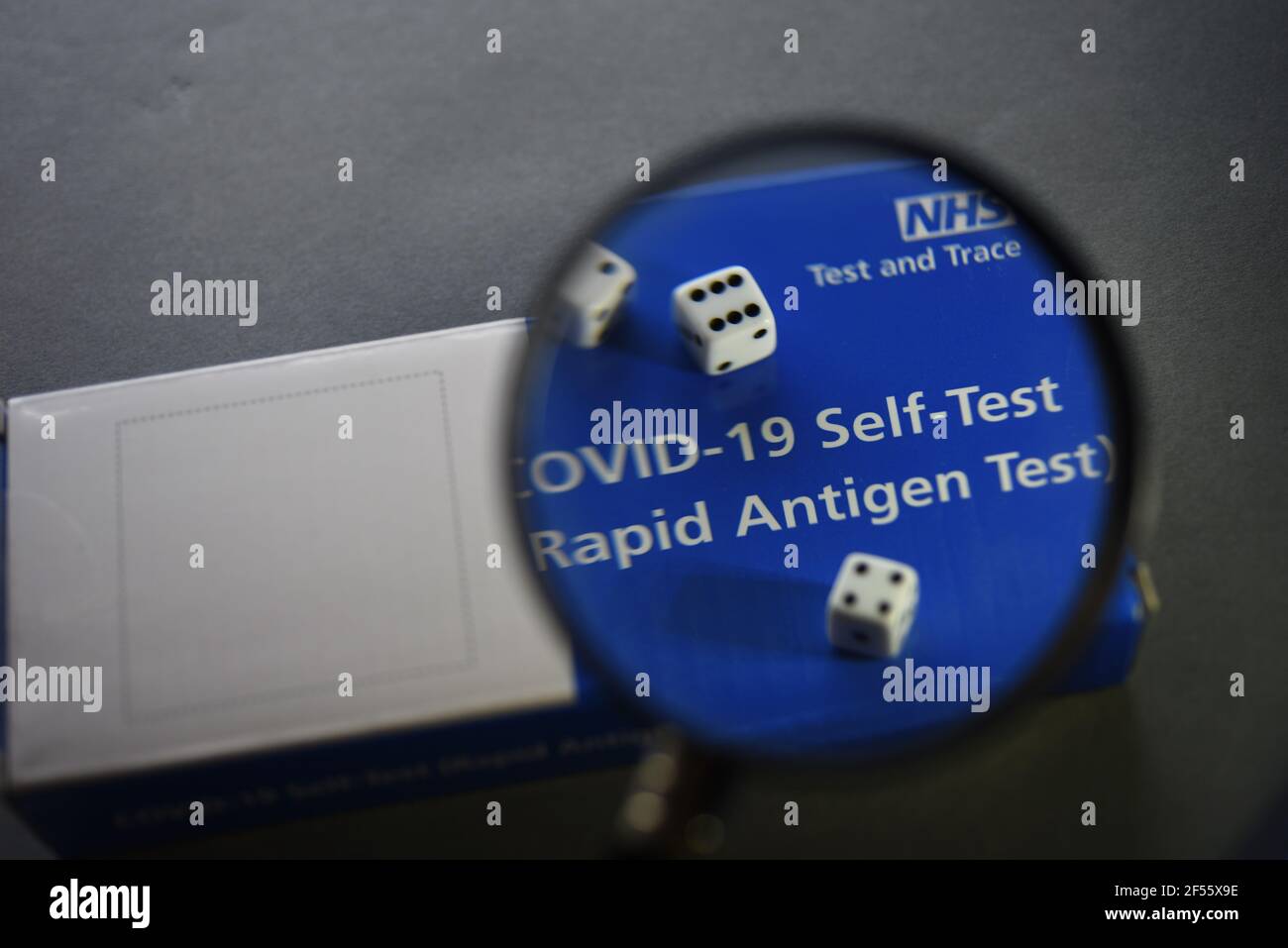A COVID-19 Self Test (Rapid Antigen Test) kit information concept image. Selective focus through a magnifying glass. Stock Photo