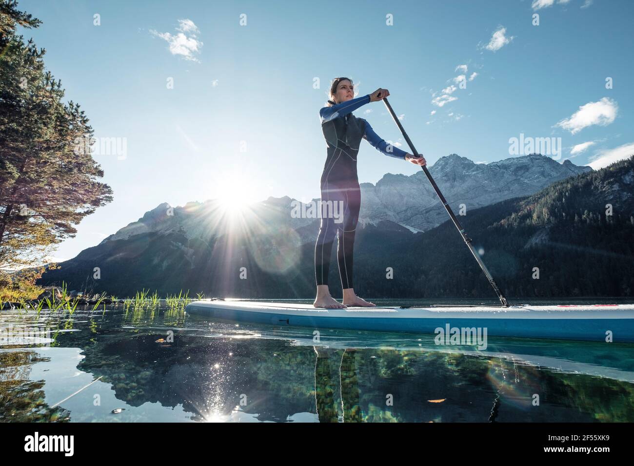 Germany, Bavaria, Garmisch Partenkirchen, Young woman stand up paddling