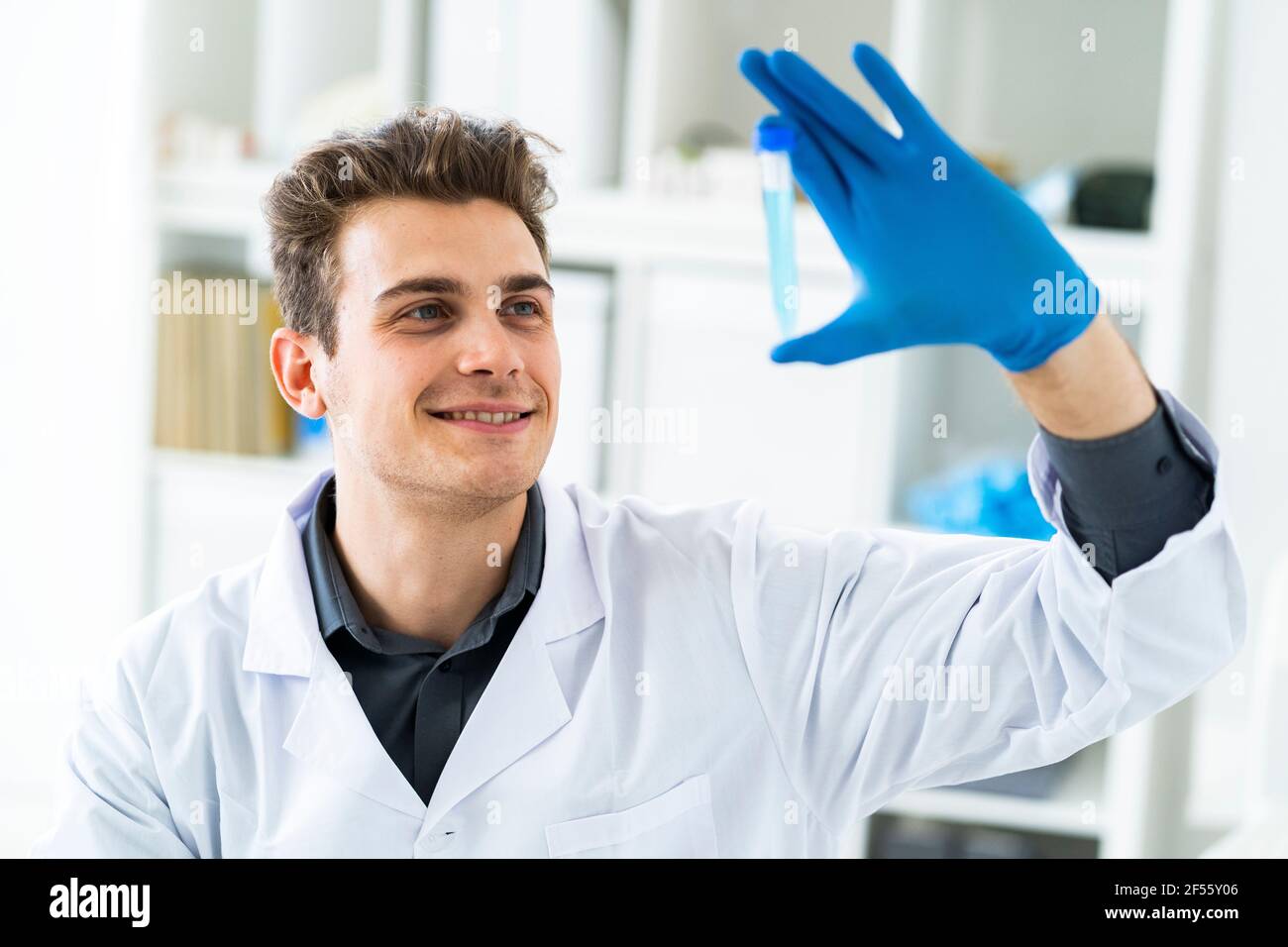 Smiling male scientist examining liquid in test tube Stock Photo