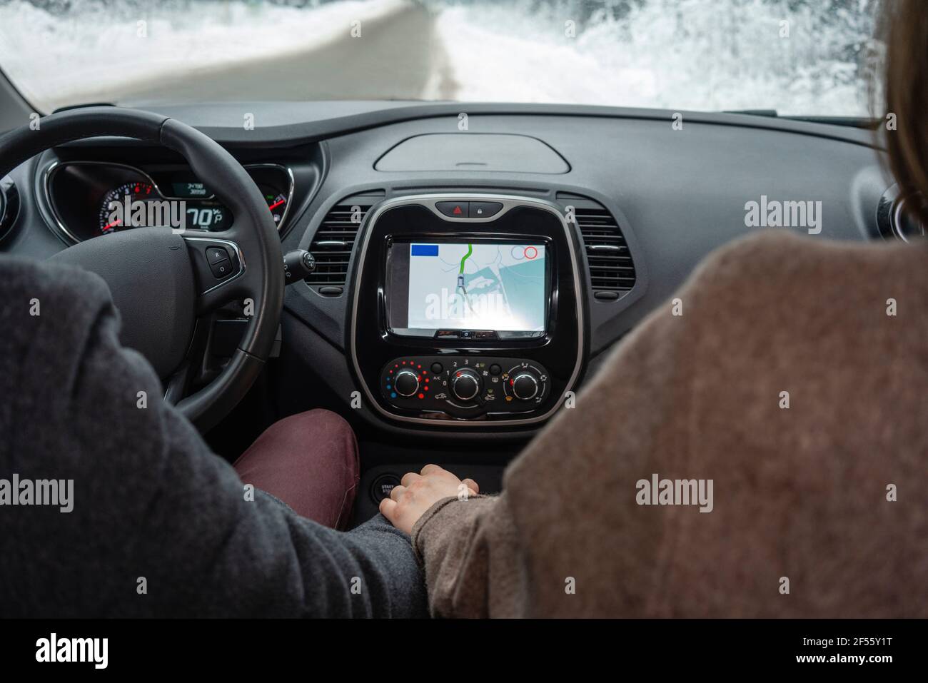 Couple using car navigational system while sitting in car Stock Photo