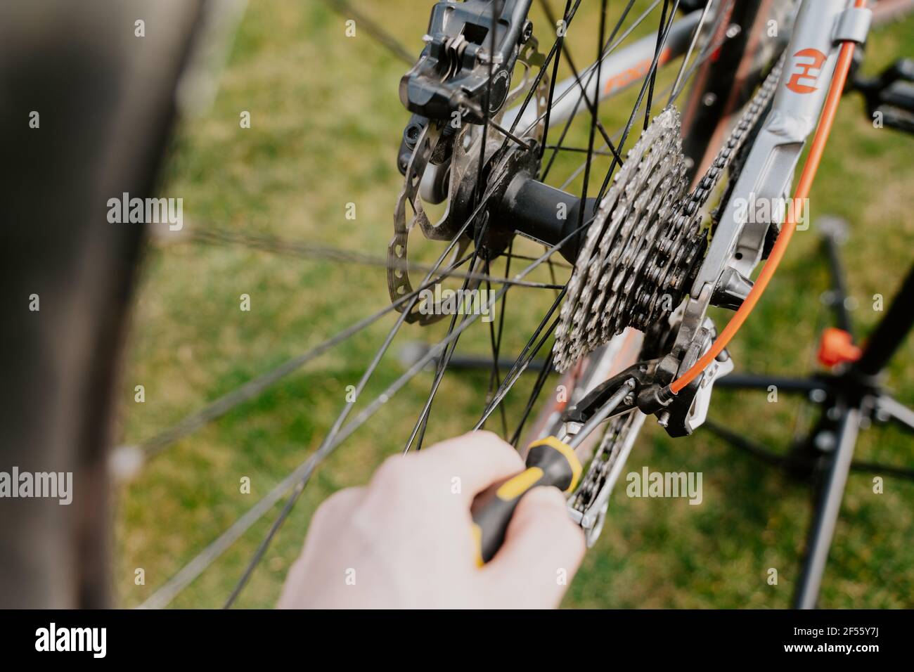 Closeup of bicycle mechanic with a screwdriver repairing bicycle Stock Photo