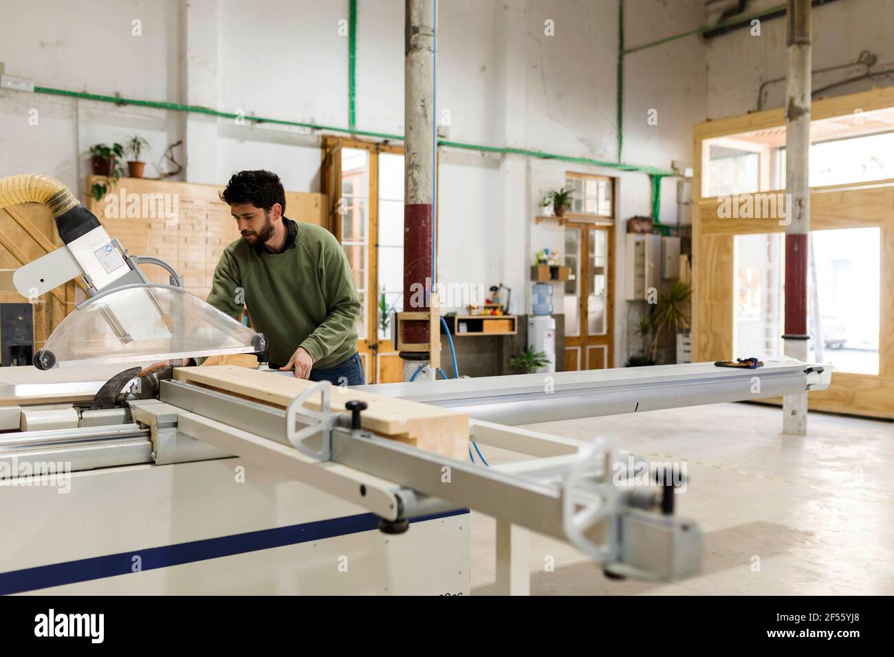 Male carpenter working with table saw in workshop Stock Photo