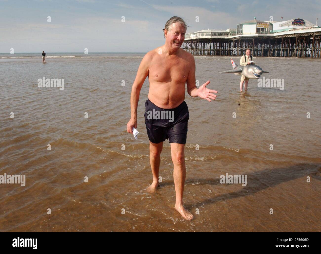 MEACHER EMERGES FROM THE WATER IN BLACKPOOL AFTERH HIS SWIM GREETED BY A FOE SHARK PROTESTING ABOUT AIRCRAFT POLLUTION. 2/10/02 PILSTON Stock Photo