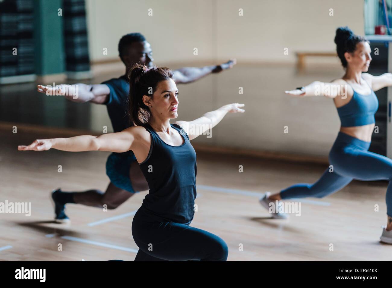 Female and male athlete friends in warrior position in gym Stock Photo