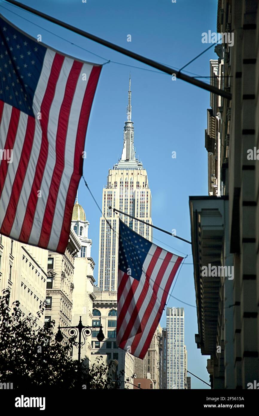 USA, New York, New York City, American flags hanging against Empire State Building Stock Photo