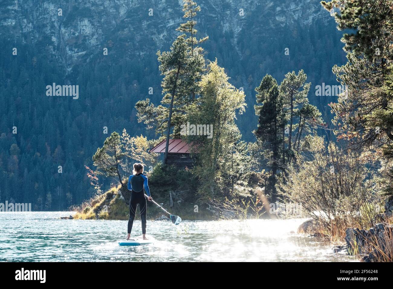 Germany, Bavaria, Garmisch Partenkirchen, Young woman stand up paddling