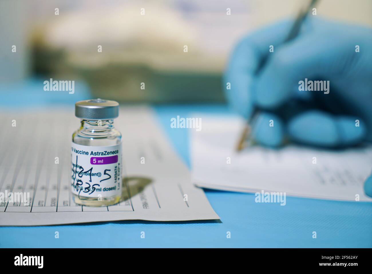 Vial of COVID-19 vaccine produced by AstraZeneca. Doctor's hand in a medical glove holds a bottle with a coronavirus vaccine. Selective focus. Turin, Stock Photo