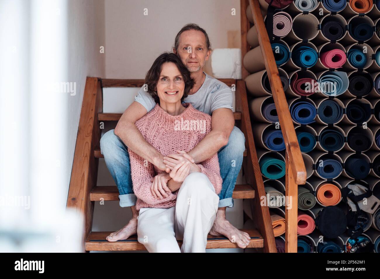 Happy matured couple sitting on stairs at health studio Stock Photo