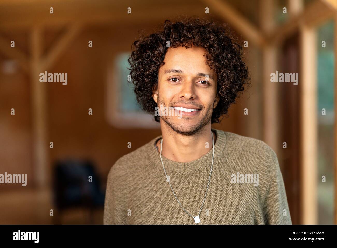Young man smiling while standing at spacious room Stock Photo