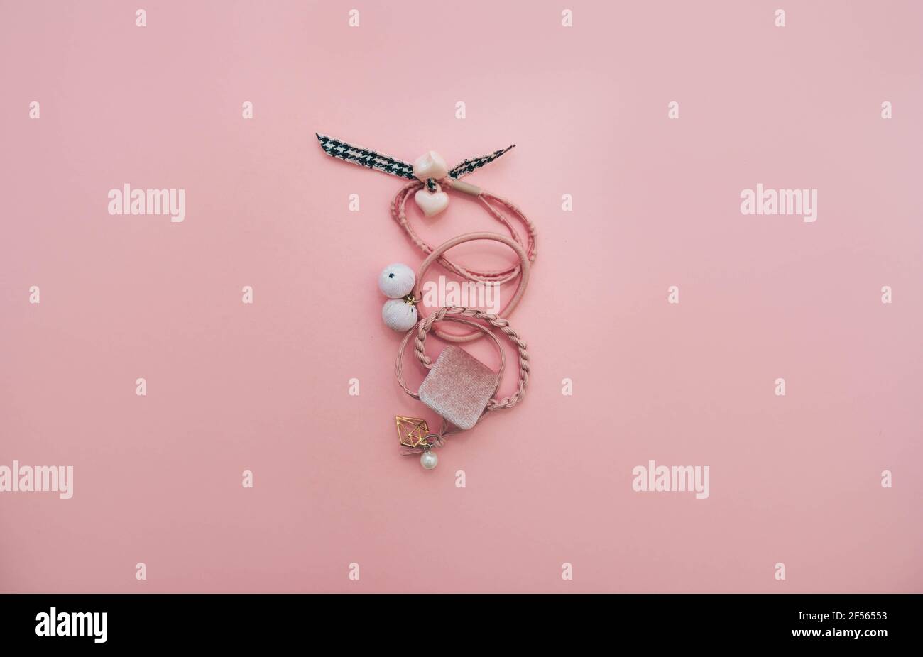 Pink hair elastic bands isolated on pastel pink background. Hair