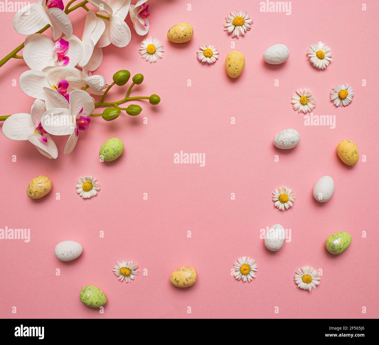 Colorful Easter eggs and flowers on pink background. Spring holidays ...
