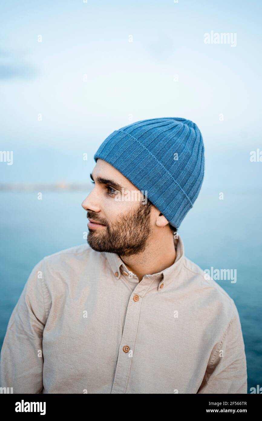 Smiling businessman in knit hat looking away Stock Photo