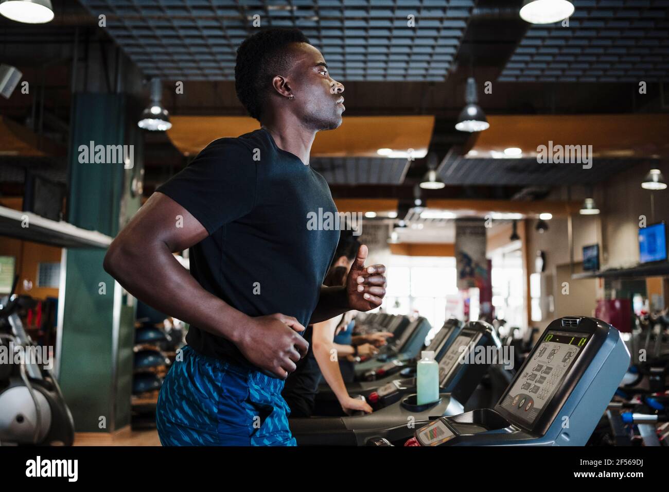 Man running on treadmill in gym Stock Photo