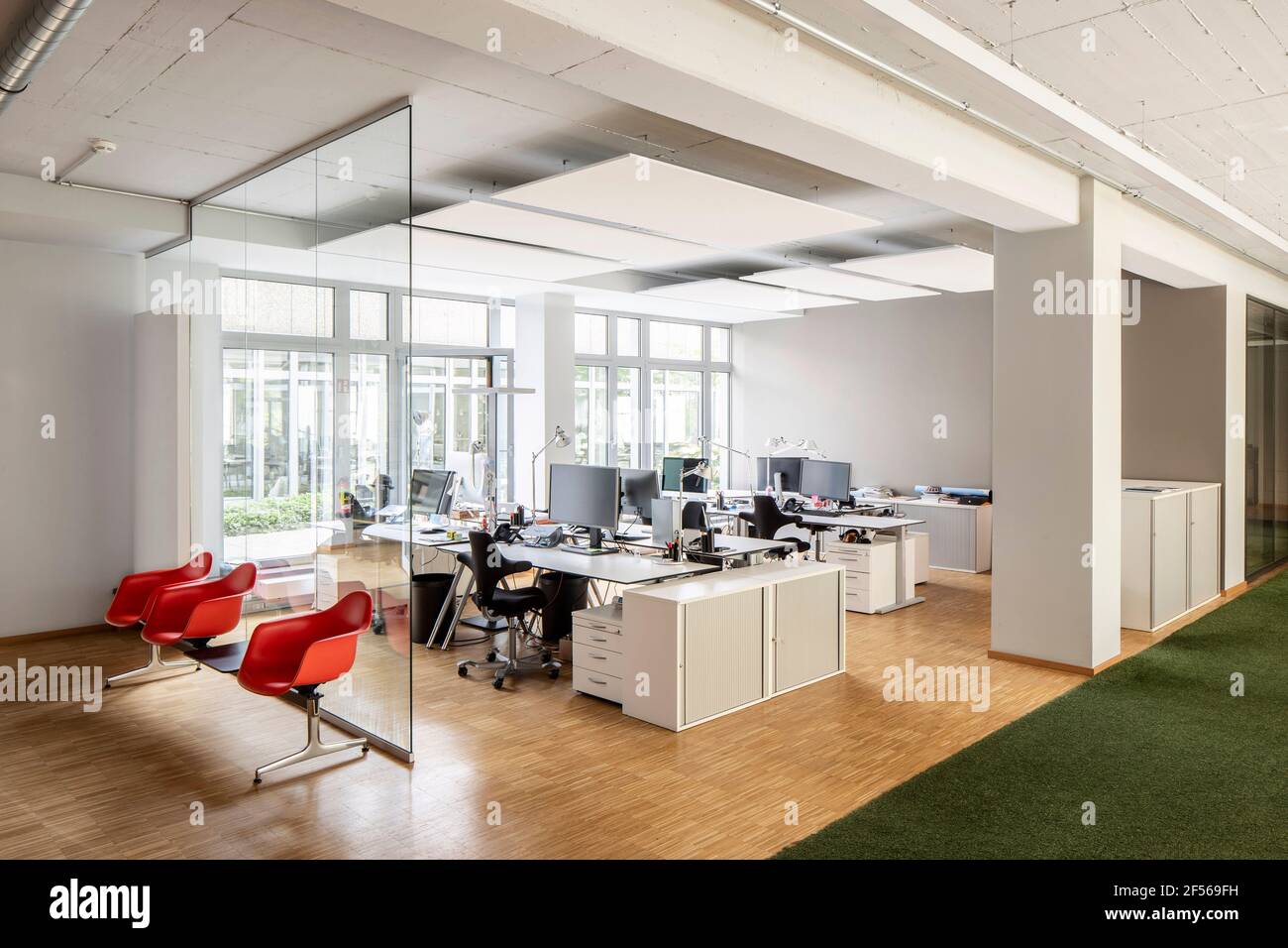 Chairs at desk with computers in open plan office Stock Photo - Alamy
